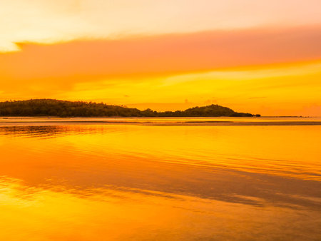 Beautiful tropical beach sea and ocean with coconut palm tree at sunrise time for travel and vacationの写真素材