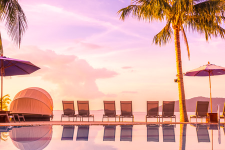 Beautiful outdoor view with umbrella and chair around swimming pool in luxury hotel and resort at sunrise time for travel and vacationのeditorial素材
