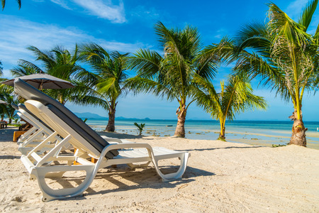 Beautiful outdoor sea and ocean view with umbrella and chair around coconut palm tree for travel and...