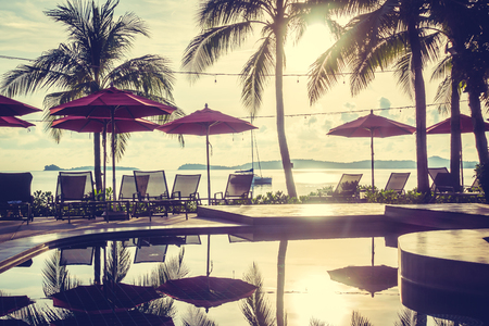 Beautiful luxury outdoor swimming pool with umbrella and chair in hotel and resort for travel and vacationの写真素材