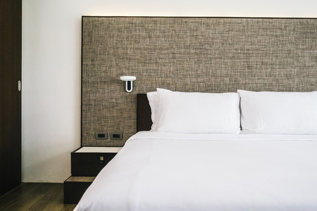 White comfortable pillow on bed decoration interior of hotel bedroomの写真素材