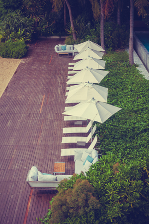 Beautiful luxury umbrella and chair around swimming pool in hotel and resort for travel and vacationの写真素材