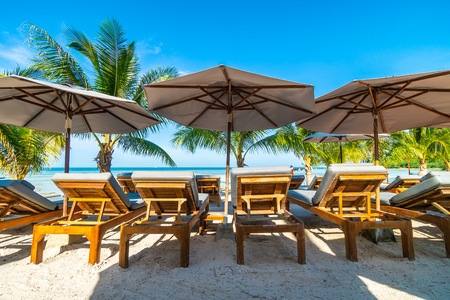 Beautiful outdoor sea and ocean view with umbrella and chair around coconut palm tree for travel and vacationの写真素材