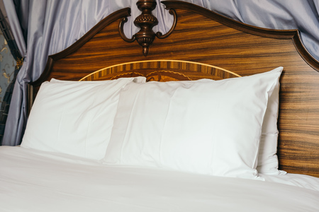 Beautiful comfortable white pillow on bed decoration in hotel bedroom interiorの写真素材