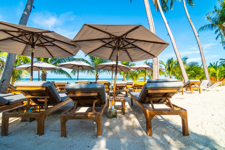 Beautiful outdoor sea and ocean view with umbrella and chair around coconut palm tree for travel and vacationの写真素材
