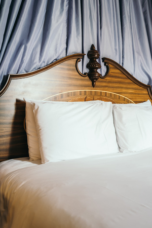 Beautiful comfortable white pillow on bed decoration in hotel bedroom interiorの写真素材