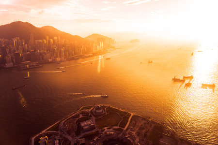 Beautiful colorful sunset in hong kong city skyline with sea and ocean bayのeditorial素材