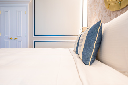 Comfotable pillow on bed with light lamp decoration interior of bedroom