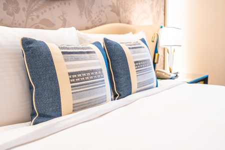 Comfotable pillow on bed with light lamp decoration interior of bedroom