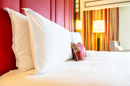 Comfotable pillow on bed with light lamp decoration interior of bedroomの写真素材