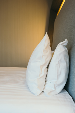 White pillow on bed decoration in hotel bedroom interiorの写真素材