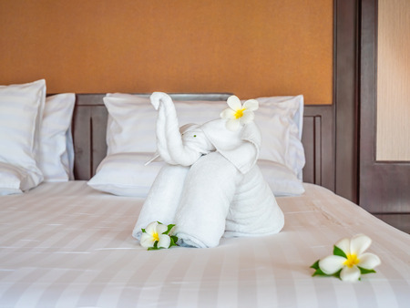 White elephant towel and comfortable pillow on bed decoration in hotel bedroom interiorの写真素材