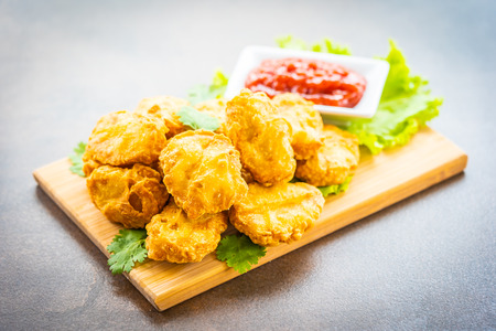 Deep fried chicken meat call nugget with tomato or ketchup sauce on wood plate - Junk and fast foodの写真素材
