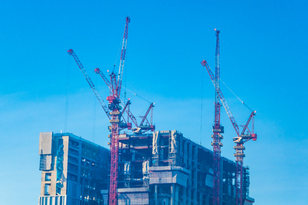 Crane construction site building exterior with blue skyの写真素材