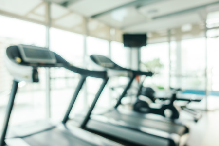Abstract blur and defocused fitness sport equipment in gym room interior for background