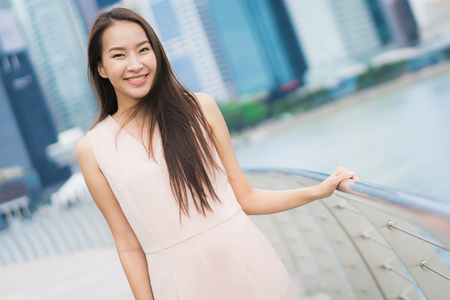 Beautiful asian woman smile and happy to travel in singapore cityの写真素材