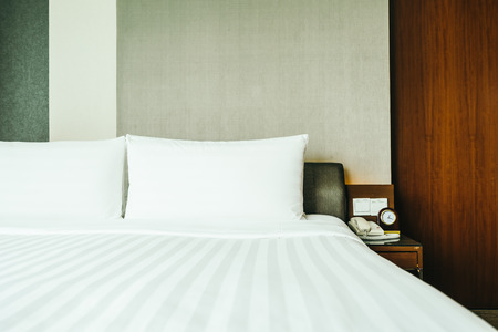 White comfortable pillow on bed decoration in hotel bedroom interiorの写真素材