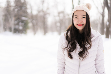 Beautiful young asian woman smiling happy with travel in snow winter season at Hokkaido Japanの写真素材