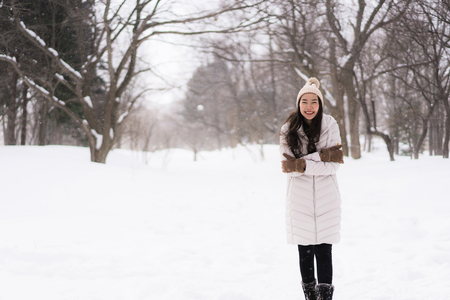 Beautiful young asian woman smiling happy with travel in snow winter season at Hokkaido Japanの写真素材