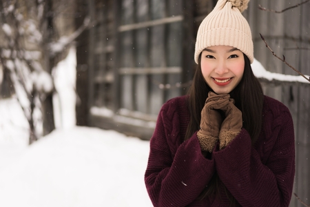 Beautiful young asian woman smiling happy with travel in snow winter season at Hokkaido Japanの写真素材