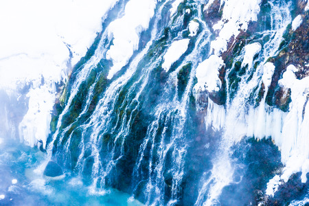 Beautiful outdoor nature landscape with shirahige waterfall and bridge in snow winter season Hokkaido Japanの写真素材