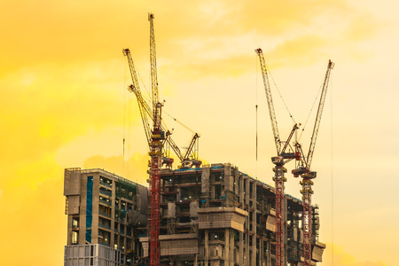 Crane construction site building exterior at sunset timeの写真素材