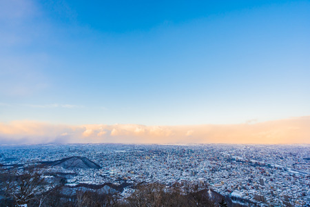 Beautiful landscape with moiwa mountain around tree and city in snow winter season at sunset time in Sapporo Hokkaido Japanの写真素材
