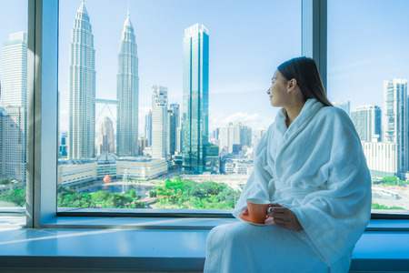 Young asian woman travel around Kuala lumpur and enjoy coffee cup and looking the city in Malaysiaのeditorial素材