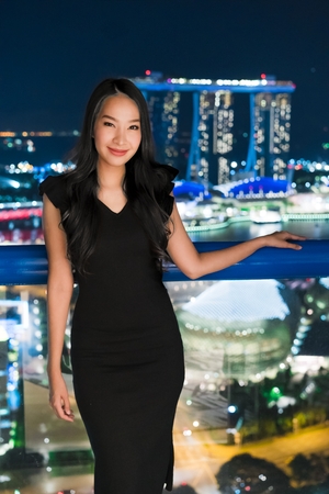 Beautiful Asian women smile and happy with singapore city view at nightのeditorial素材