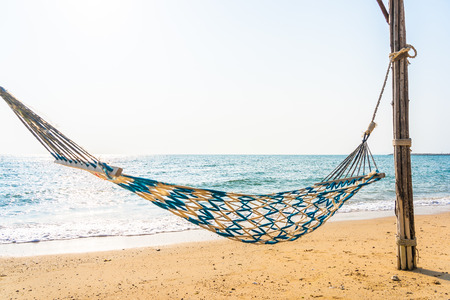 Empty hammock swing on the beautiful beach and sea for holiday vacation travel and leisure conceptの写真素材