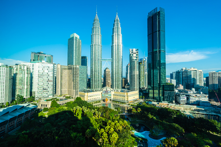 Beautiful architecture building exterior city in kuala lumpur skyline with white cloud and blue skyのeditorial素材