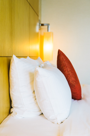 White comfortable pillow on bed decoration in hotel bed room interiorの写真素材