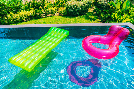 Colorful swim ring or rubber float around swimming pool water for leisure relax