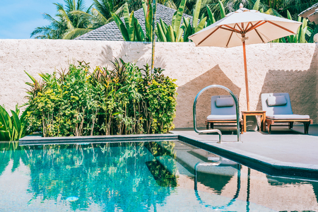 Umbrella and chair around swimming pool neary beautiful landscape of sea ocean beach with blue sky and white cloud for leisure travel and vacationのeditorial素材