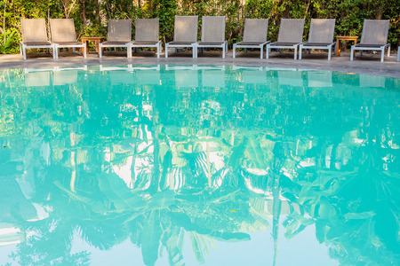 Empty chair around swimming pool in hotel resort for travel leisure and vacation concept