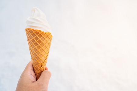Hand holding ice cream with cone - sweet dessert foodの写真素材