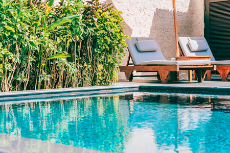 Umbrella and chair around swimming pool neary beautiful landscape of sea ocean beach with blue sky and white cloud for leisure travel and vacationのeditorial素材