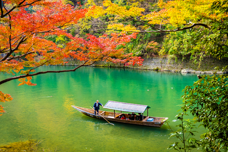 Beautiful Arashiyama river with maple leaf tree and boat around lake in Autumn season Kyoto Japanのeditorial素材