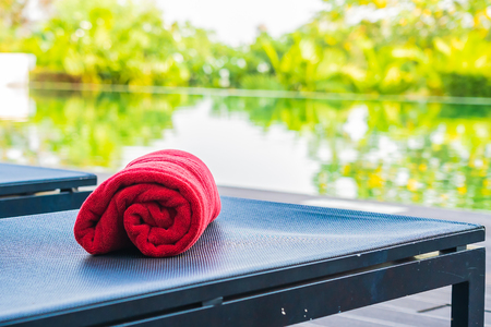 Towel pool on chair and bed around swimming pool in hotel and resort for using take a bathの写真素材
