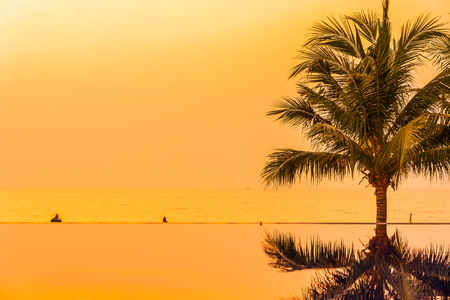 Beautiful landscape outdoor with coconut palm tree around swimming pool in hotel and resort at sunrise or sunset time for leisure vacation and travelの写真素材