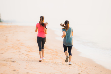 Portrait beautiful young sport asian woman running and exercise on the beach near sea and ocean at sunrise or sunset time for healthy conceptの写真素材