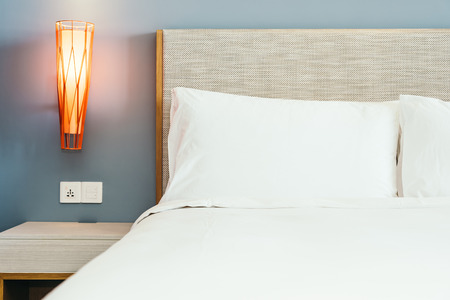 Beautiful luxury comfortable pillow on bed with light lamp furniture decoration interior of bedroom