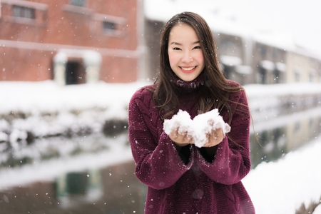 Beautiful young asian woman smile and happy with travel trip at Otaru canal Hokkaido Japan in Snow...