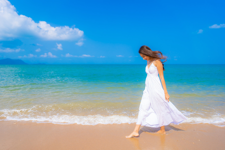 Portrait beautiful young asian woman happy smile leisure on the beach sea and ocean with blue sky white cloud for vacation travelの写真素材