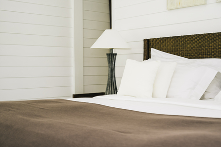 Beautiful luxury comfortable pillow on bed with light lamp decoration in bedroom interiorの写真素材