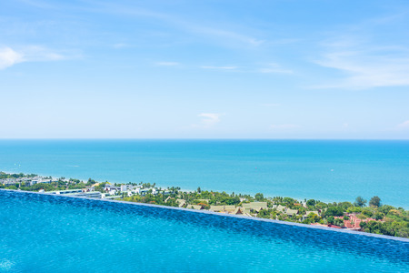 Beautiful outdoor landscape of infinity swimming pool  with sea ocean on white cloud blue sky view for leisure travel in holiday vacationの写真素材