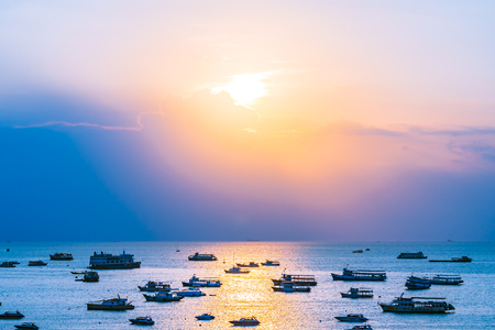 A lot of ship or boat on the sea ocean of Pattaya bay and city in Thailand at Sunsetの写真素材
