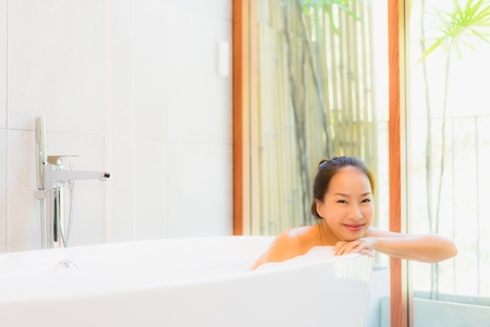 Portrait young beautiful asian woman take a bath in bathtub for leisure relax and in bathroom interiorの写真素材
