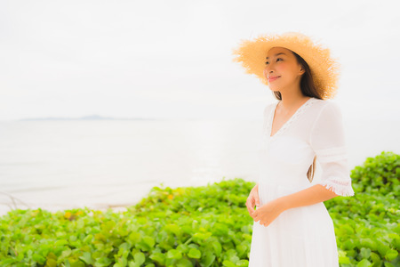 Portrait beautiful asian woman wear hat with smile happy leisure on the beach and sea ocean in holiday vacationの写真素材