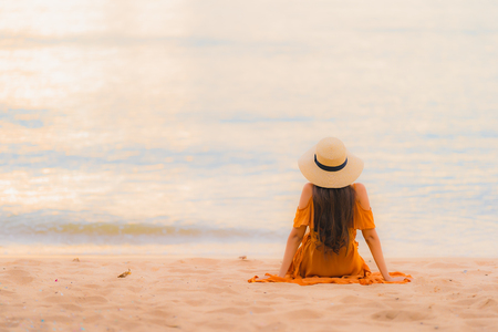 Portrait beautiful young asian woman happy smile relax on the beach sea ocean at sunset time in holiday vacationの写真素材